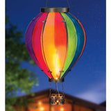 Rainbow XLG Hot Air Balloon Solar Lantern hanging at night with colorful glass and flickering solar LED light.