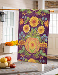 Decorative house flag with floral and pumpkin design hanging on a door