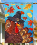 Decorative flag with a turkey wearing a pilgrim hat on a blue background with autumn leaves.