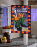 Decorative Halloween flag with a witch's boots, flowers, and 'Happy Halloween' text on a porch.