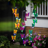 Colorful butterfly-shaped wind chimes in a garden setting.