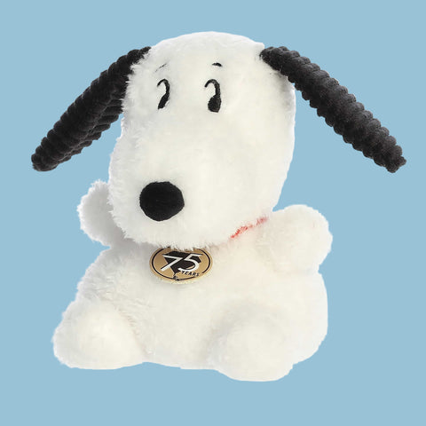 White plush dog toy with black ears and nose on a blue background
