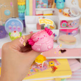 Hand holding a pink squishy toy with a colorful background