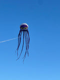 Jellyfish-shaped kite flying against a clear blue sky