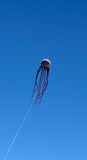 Kite shaped like a jellyfish flying against a clear blue sky