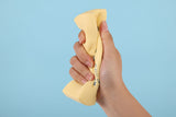 Hand holding a yellow sponge with a blurred background