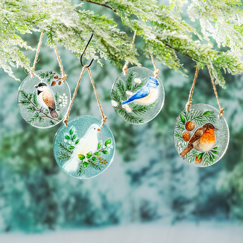 Woodland Storybook Suncatchers with detailed hand-painted birds hanging on a string against a wintery background.