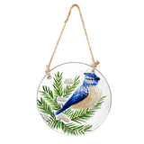 Woodland Storybook Suncatchers featuring a Blue Jay on a round glass design with green pine branches.