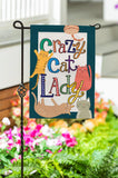 Decorative garden flag with 'Crazy Cat Lady' text and cat illustrations, set against a garden background.