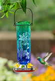 Hummingbird feeder with floral design hanging in a garden