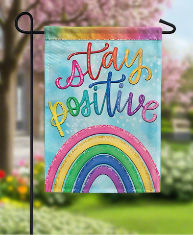 Decorative garden flag with 'stay positive' text and rainbow design on a white background