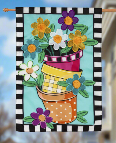 Decorative garden flag with colorful flower pots and flowers on a black and white striped border.