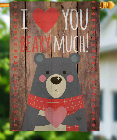 Decorative flag with a bear holding a heart and text 'I ❤️ YOU BEARY MUCH!' on a wooden background.