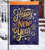 Happy New Year garden flag with gold text on a purple background, displayed outdoors in snow.