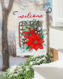 Decorative garden flag with poinsettias and 'welcome' text in a winter setting.