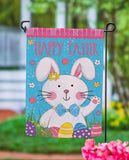 Garden flag with Easter bunny design and 'Happy Easter' text, outdoors.
