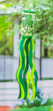 Green and white windsock with shamrock design against a blurred garden background