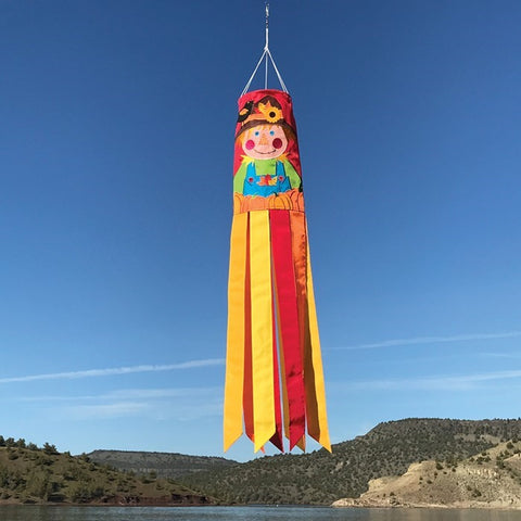 Colorful windsock with a character design against a blue sky and mountainous landscape.