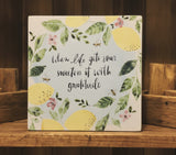 Decorative box with lemon and leaf design and motivational quote on a light background