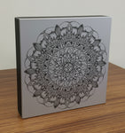 Decorative box with a black mandala design on a gray background
