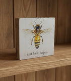 Decorative block with a bee illustration and 'just bee happy' text on a light background