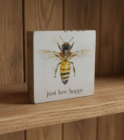 Decorative block with a bee illustration and 'just bee happy' text on a light background