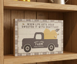 Decorative sign with a truck and fruit design, featuring text about life and gratitude.